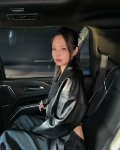 a woman sitting in the back seat of a car with her hands on her hips