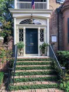 a blue door with an american flag on the top and stairs leading up to it