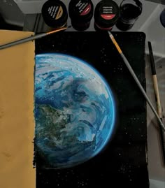 an artist's work with paints and brushes on the table