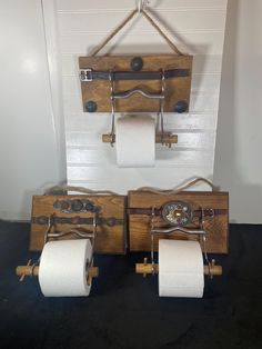 two wooden toilet paper holders with metal handles and wheels on the wall next to each other