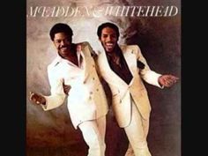 two men in white suits standing next to each other on the cover of an album