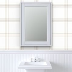 a white sink sitting under a bathroom mirror next to a wall mounted faucet