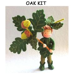 an image of a doll with leaves on it's head and holding a stick