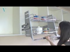 a woman is looking at the shelves in her kitchen