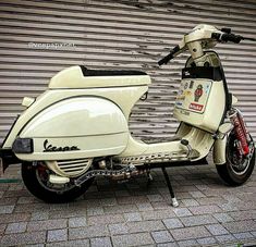 a white scooter parked in front of a garage door