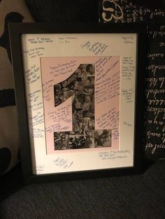 the number one is surrounded by many photos and letters on display in a black frame