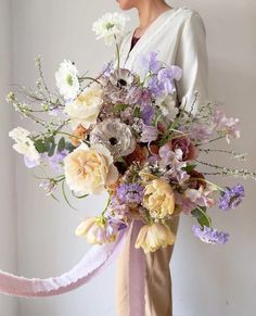 a woman holding a large bouquet of flowers