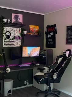 a computer desk with two monitors and a keyboard on it in front of a purple wall