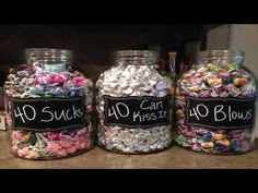 three glass jars filled with candy sitting on top of a counter