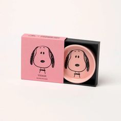 a pink box with a black and white drawing of a dog on it's face