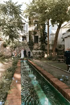 a bride and groom walking down the aisle to their wedding ceremony in an outdoor courtyard