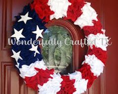 a wreath with red, white and blue stars on it is hanging on the front door