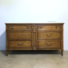 an old wooden dresser with two drawers on one side and three doors on the other