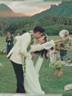 a bride and groom kissing in front of an outdoor ceremony