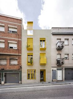 two buildings with yellow balconies on the windows