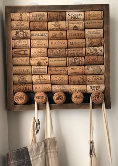 two wine corks are hanging on the wall next to some bags and purses