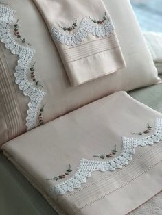 the sheets and pillowcases are all made up with lace trimming on them