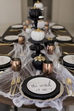 the table is set with black and gold plates