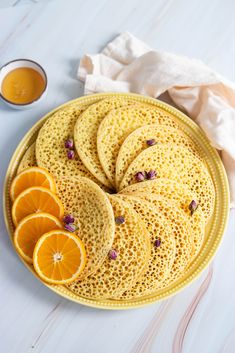 a plate with orange slices on it next to some dipping sauces and napkins