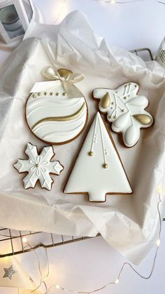 decorated cookies in the shape of christmas trees and snowflakes on a white tray