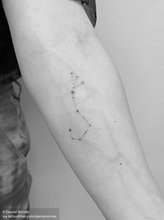 a woman's arm with a small star tattoo on the left side of her arm