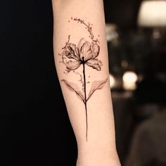 a small flower tattoo on the arm