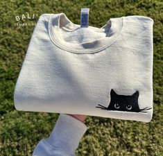 Snuggle up in style with our irresistibly adorable Cat Embroidered Sweatshirt! This cozy and charming sweatshirt features a delightful Cat Peeking design, making it the perfect wardrobe addition for any cat lover or proud cat mom/parent. HOW TO ORDER To place an order, follow these simple steps: 1. Select the size that fits you perfectly. 2. Choose your desired sweatshirt color from our selection of options. 3. Enter the thread color for the embroidery SIZING Please refer to the size chart provided in the product photos for accurate sizing. Our sweatshirts have a unisex fit, but if you prefer an oversized look, we recommend sizing up. PROCESSING TIME Once your order is placed, we'll get to work embroidering your sweatshirt with care. We strive to ship it out in 1 -3 business days using the Embroidery For Mom, Black Cat Embroidery, Cat Peeking, Cat Mom Sweatshirt, Cat Embroidery Design, Embroidered Cat, Cats Shirt, Simple Hand Embroidery Patterns, Cat Embroidery