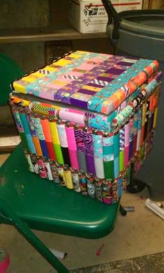 a stack of brightly colored papers sitting on top of a green chair