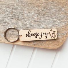 a wooden keychain with the words choose joy written in black ink on it