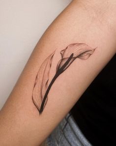 a woman's arm with a flower tattoo on the left side of her arm