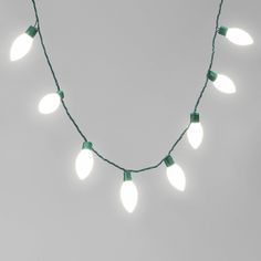 a string of christmas lights on a white background with green wire and small light bulbs