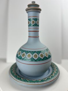 a blue and white vase sitting on top of a plate