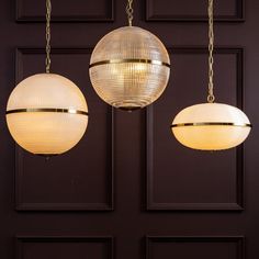 three lights hanging from the ceiling in front of a door