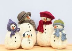 three knitted snowmen with hats and scarves