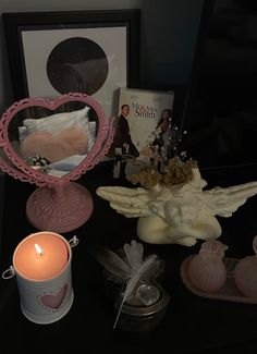 there is a candle, angel and other items on the table