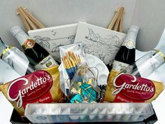 a gift basket filled with wine, chocolates and condiments for someone's special occasion