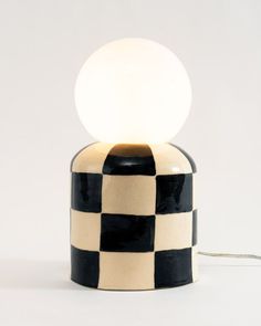 a black and white checkered lamp with a light bulb