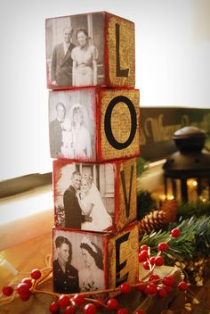 a wooden block with the word love spelled on it, surrounded by christmas decorations and pine cones