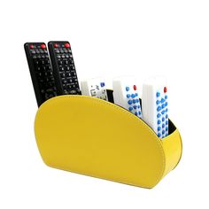 a pen holder with four remotes in it on a white background and one is yellow