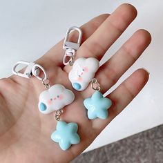 a hand holding four different shaped key chains