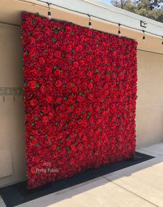 a large red flowered wall on the side of a building