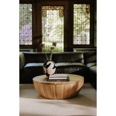 a living room with black leather couches and a round coffee table