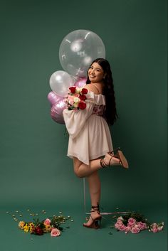 a woman in a short dress holding flowers and balloons