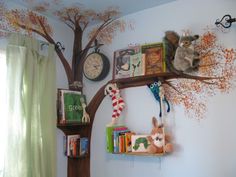 there is a tree with books on it and stuffed animals hanging from the branches above