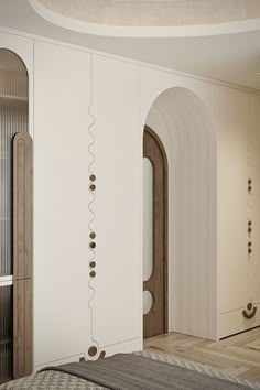 a bedroom with white walls and wooden flooring next to a bed in front of a doorway