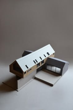 an architectural model of a building on top of a white surface with no people around it