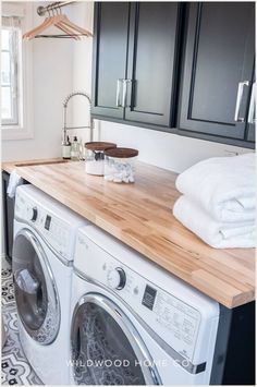 a washer and dryer sitting next to each other on top of a wooden counter