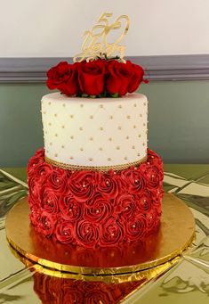 a three tiered cake with red roses on top and the number 55 on it