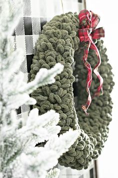 two wreaths hanging from the side of a door