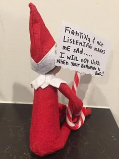 an elf is holding a sign that says, i'm not listening to you